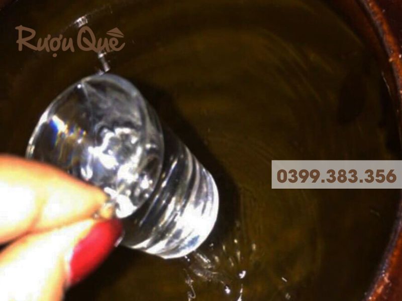 Rót rượu nếp trắng trong chum truyền thống